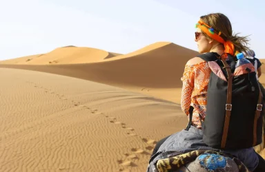 A private desert camp setup with lanterns and traditional rugs in the dunes during a marrakech desert tours 2 days