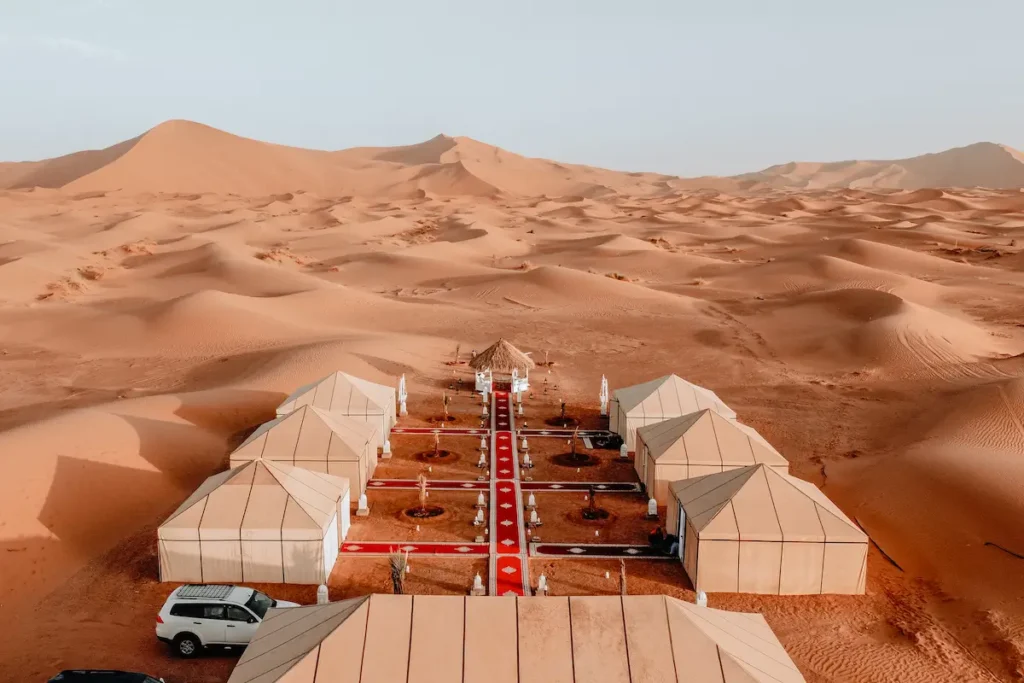 Camel caravan crossing the Erg Chebbi dunes at sunset, a key experience on our 8 day Morocco itinerary from Casablanca