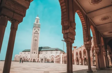 The magnificent white minaret and intricate exterior of the Hassan II Mosque against the blue Atlantic horizon in Morocco itinerary 12 days from Casablanca