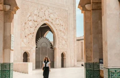 morocco itinerary 2 weeks The intricate white stone exterior and grand arches of the Hassan II Mosque against a clear blue sky in Casablanca.
